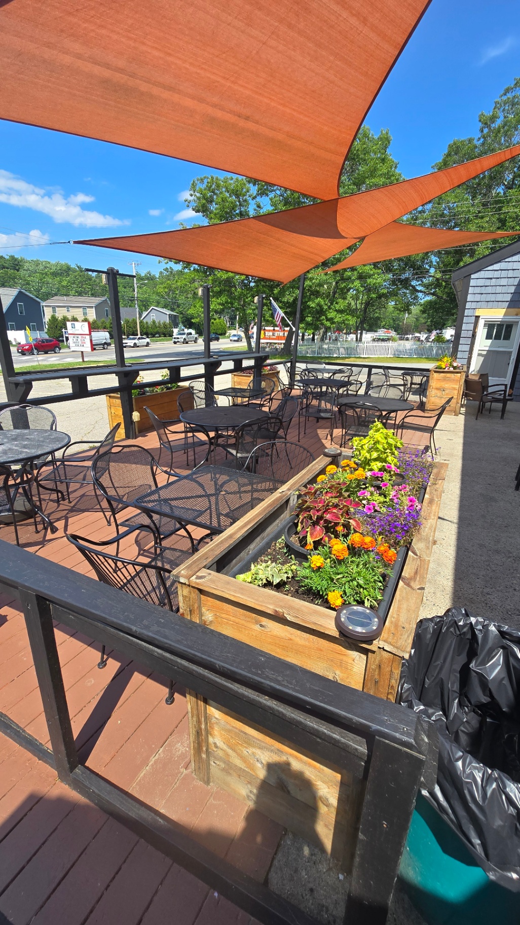 Outdoor patio with shade sails and flower planters